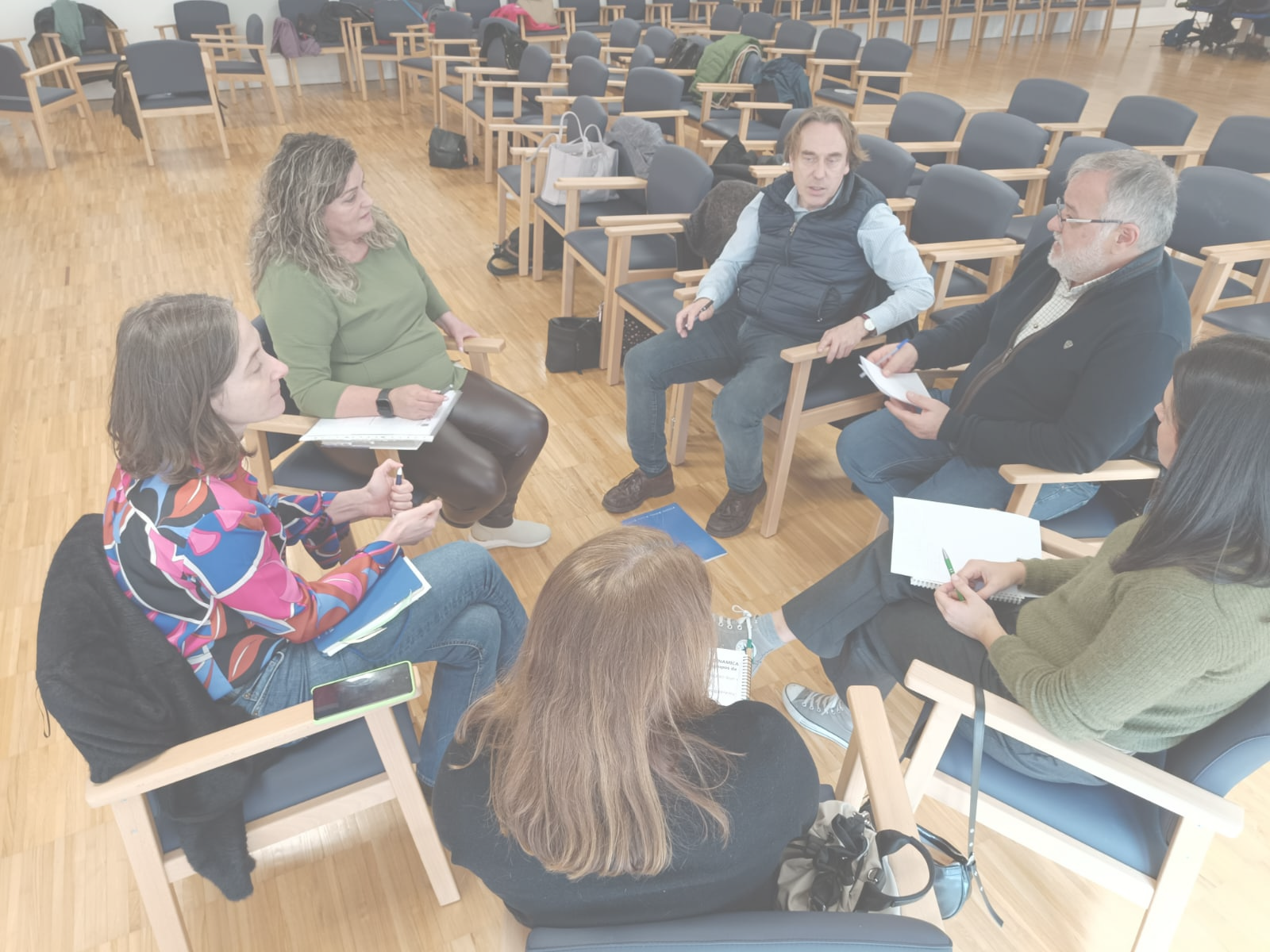 Investigación y evaluación Fotografía de grupo en sala realizando dinámica participativa con varias personas sentadas en círculo